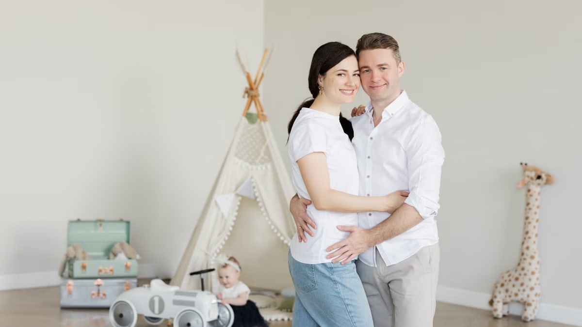 A joyful family with a toddler in a cozy room with playful decor and a teepee.